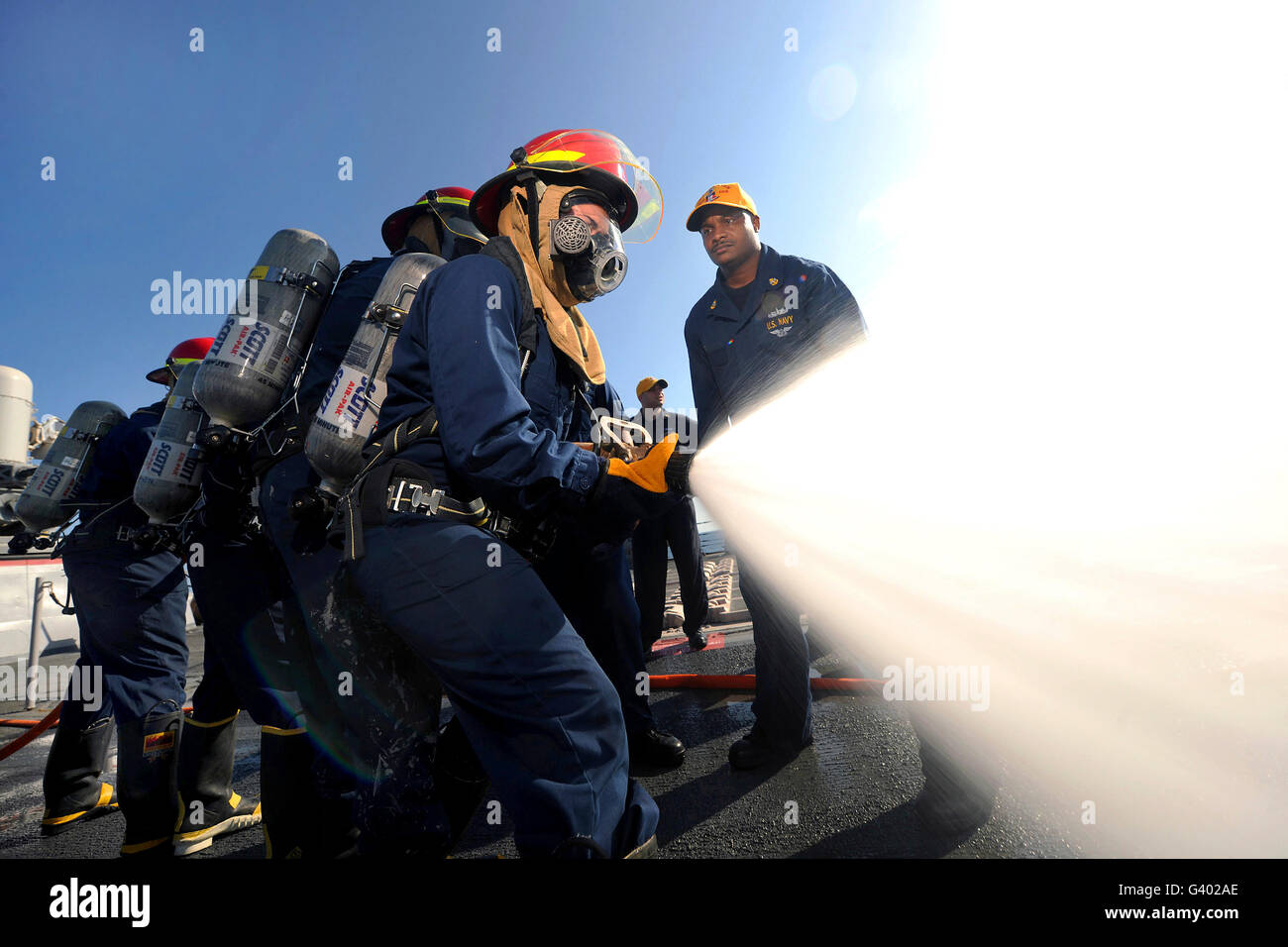 Damage Controlmen conduct fire hose handling techniques aboard USS Truxtun. Stock Photo