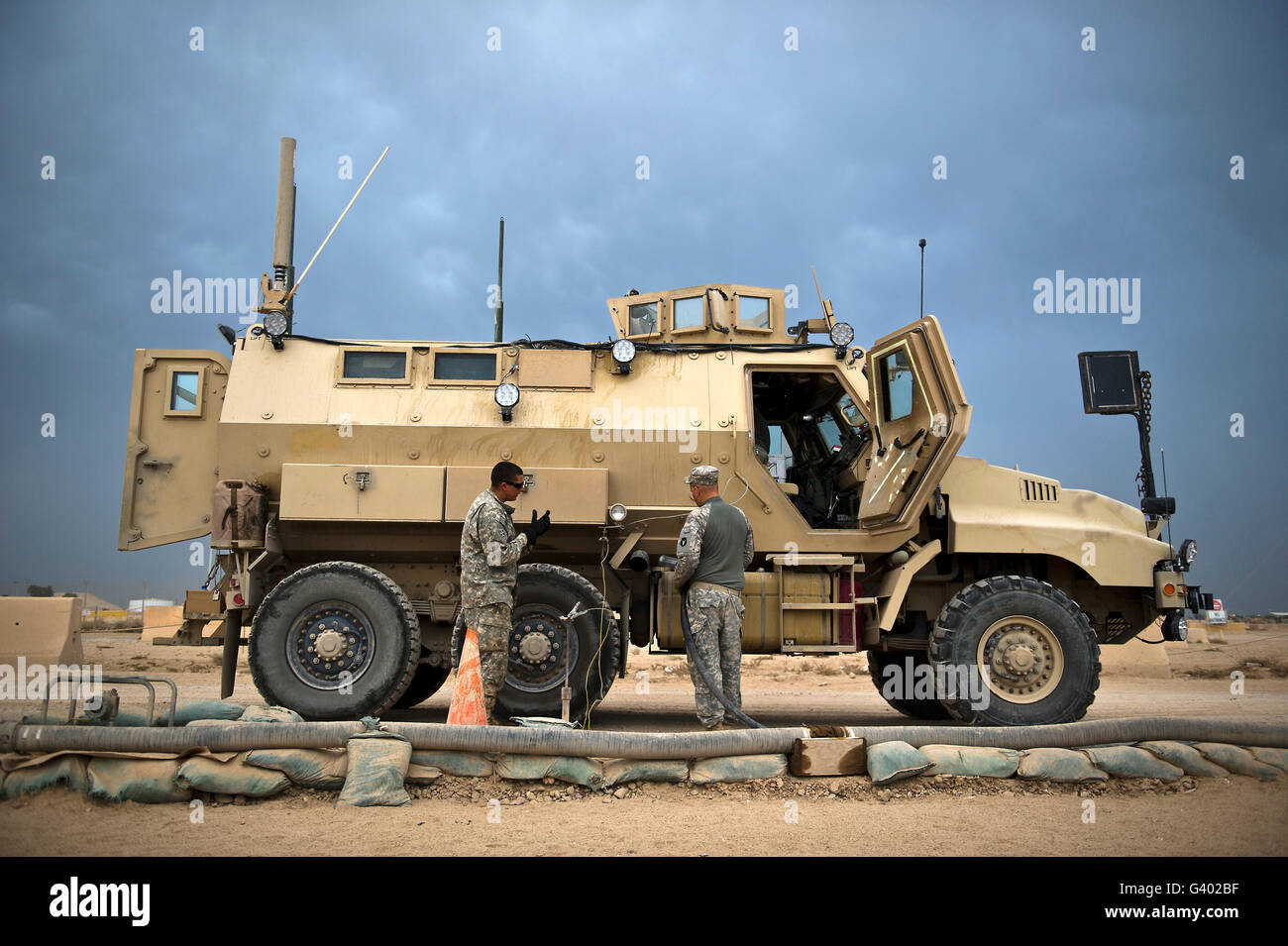 U.S. Army Sergeant refuels a Caiman MRAP vehicle, Iraq. Stock Photo
