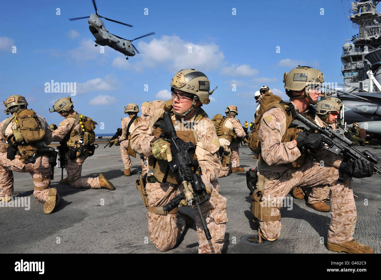 Marines position themselves on the flight deck of USS Makin Island. Stock Photo