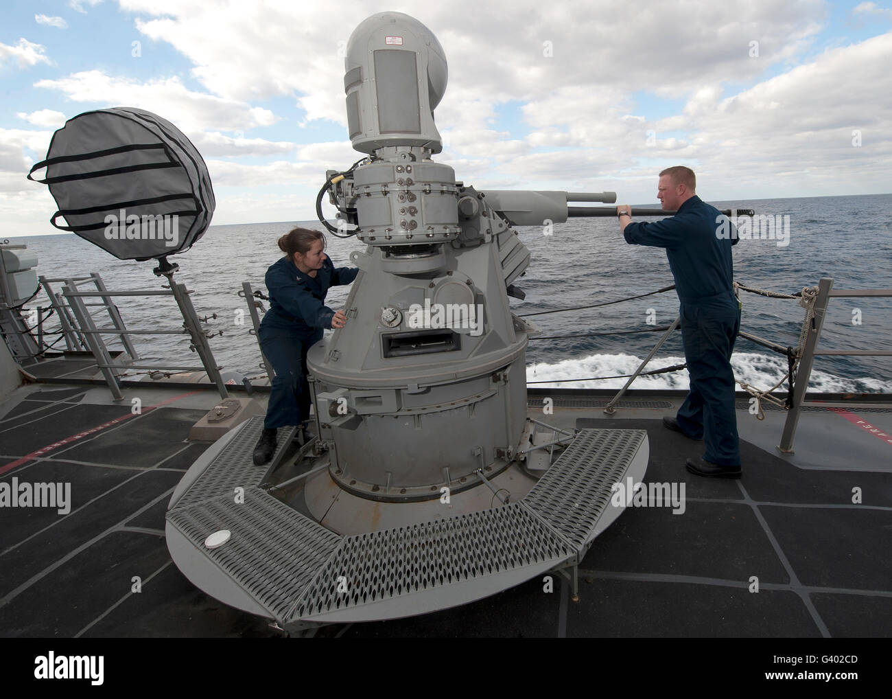 Sailors conduct maintenance on the MK38 MOD-2 25mm machine gun system. Stock Photo