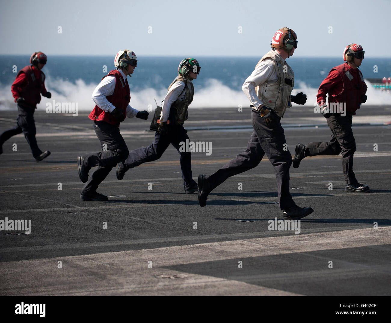 Sailors clear the landing area on the flight deck of USS Carl Vinson. Stock Photo