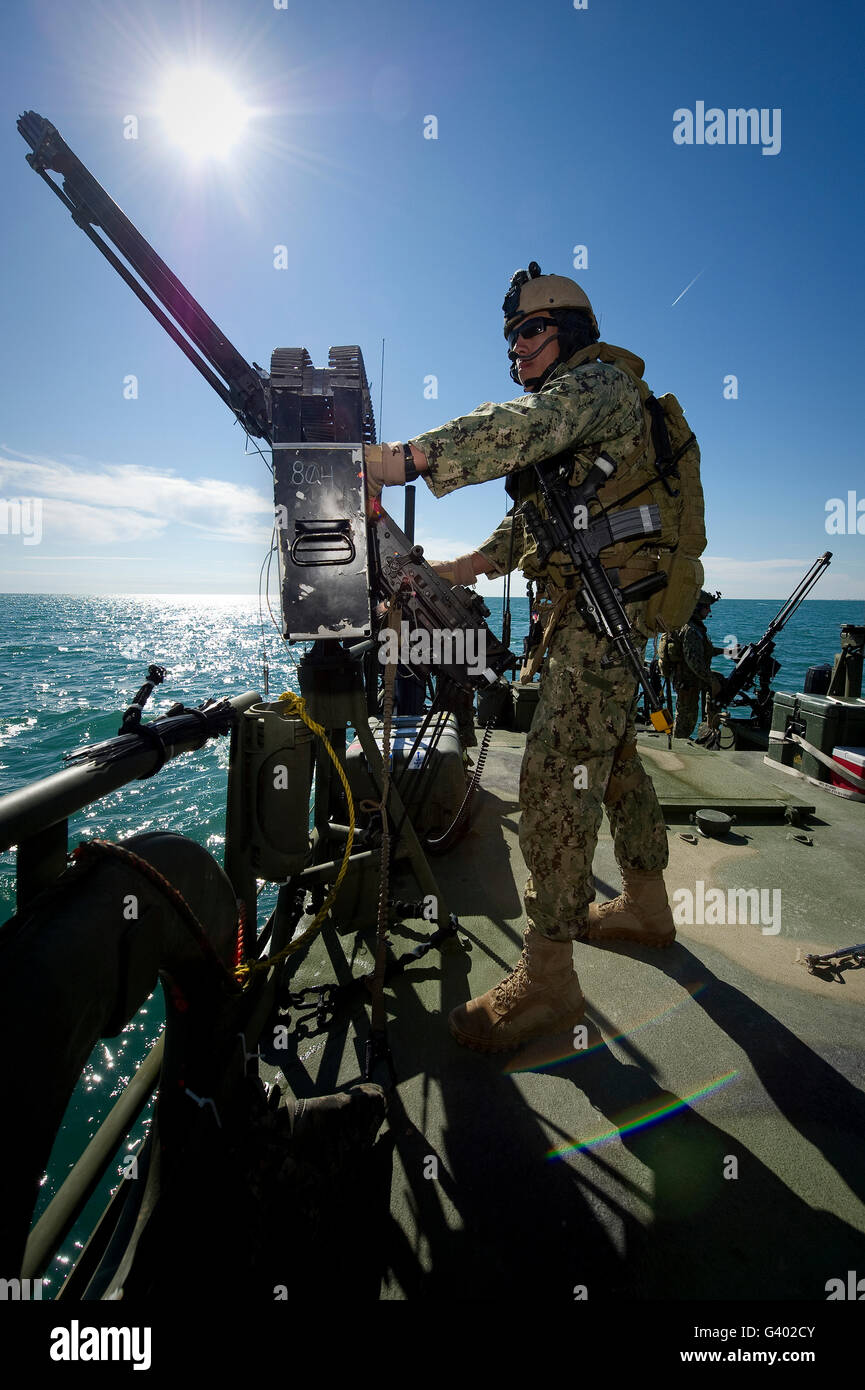 Gunner mans a M240 machine gun on a Riverine Command Boat. Stock Photo