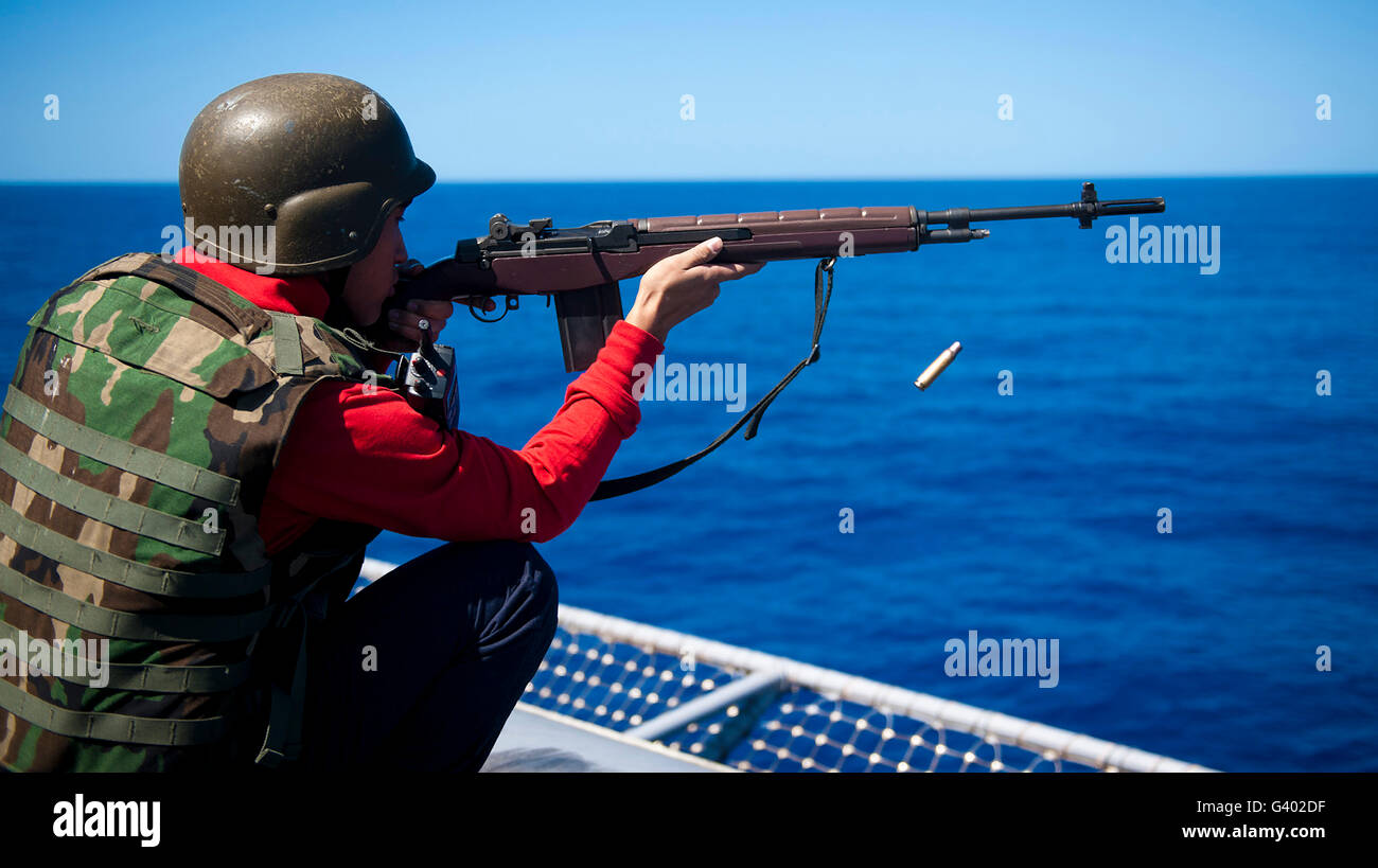 Aviation Ordnanceman fires an M-14 rifle aboard USS John C. Stennis. Stock Photo