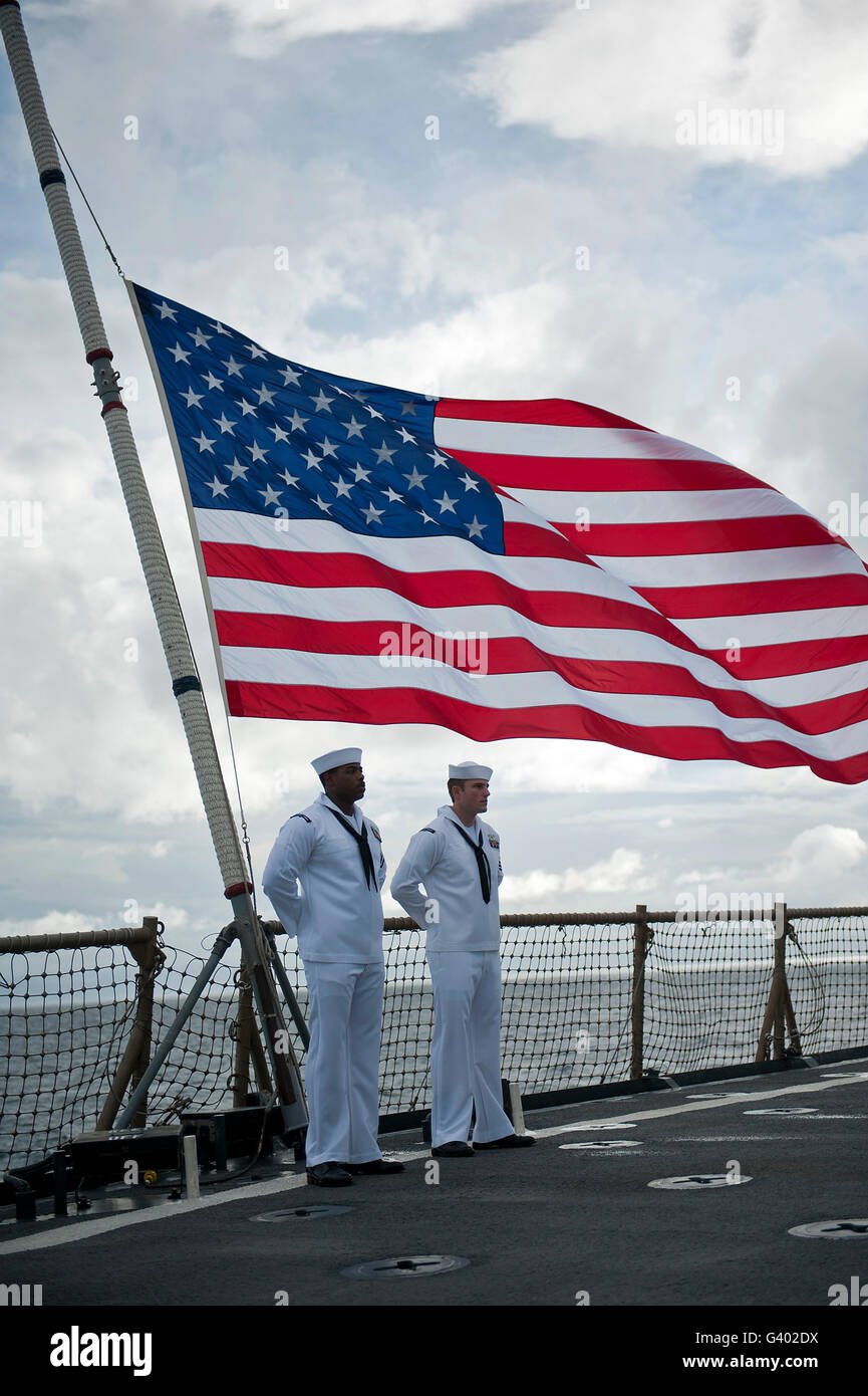 Sailors stand at parade rest during a remembrance ceremony aboard USS Pearl Harbor. Stock Photo