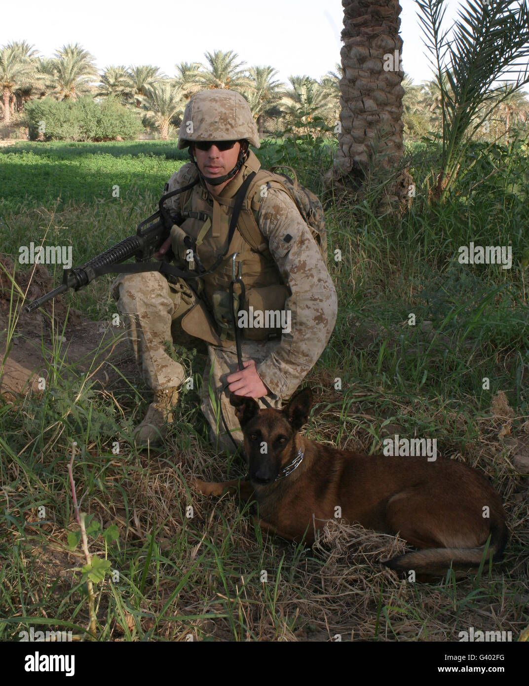 A soldier and his search dog taking a break. Stock Photo