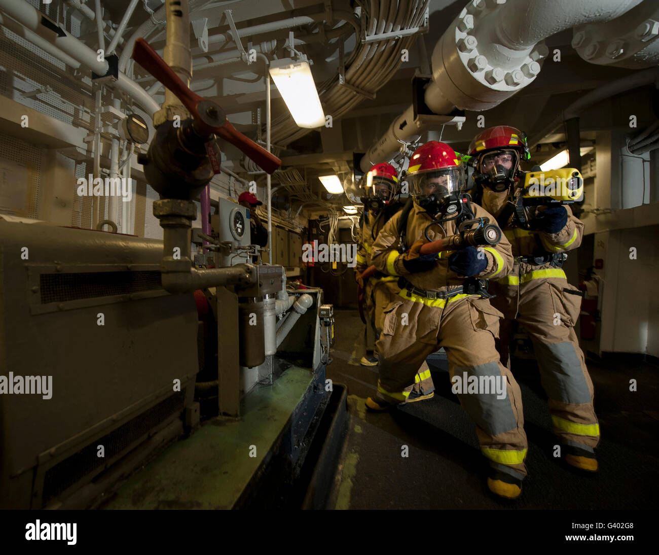 Firemen combat a simulated fire aboard USS Carl Vinson. Stock Photo