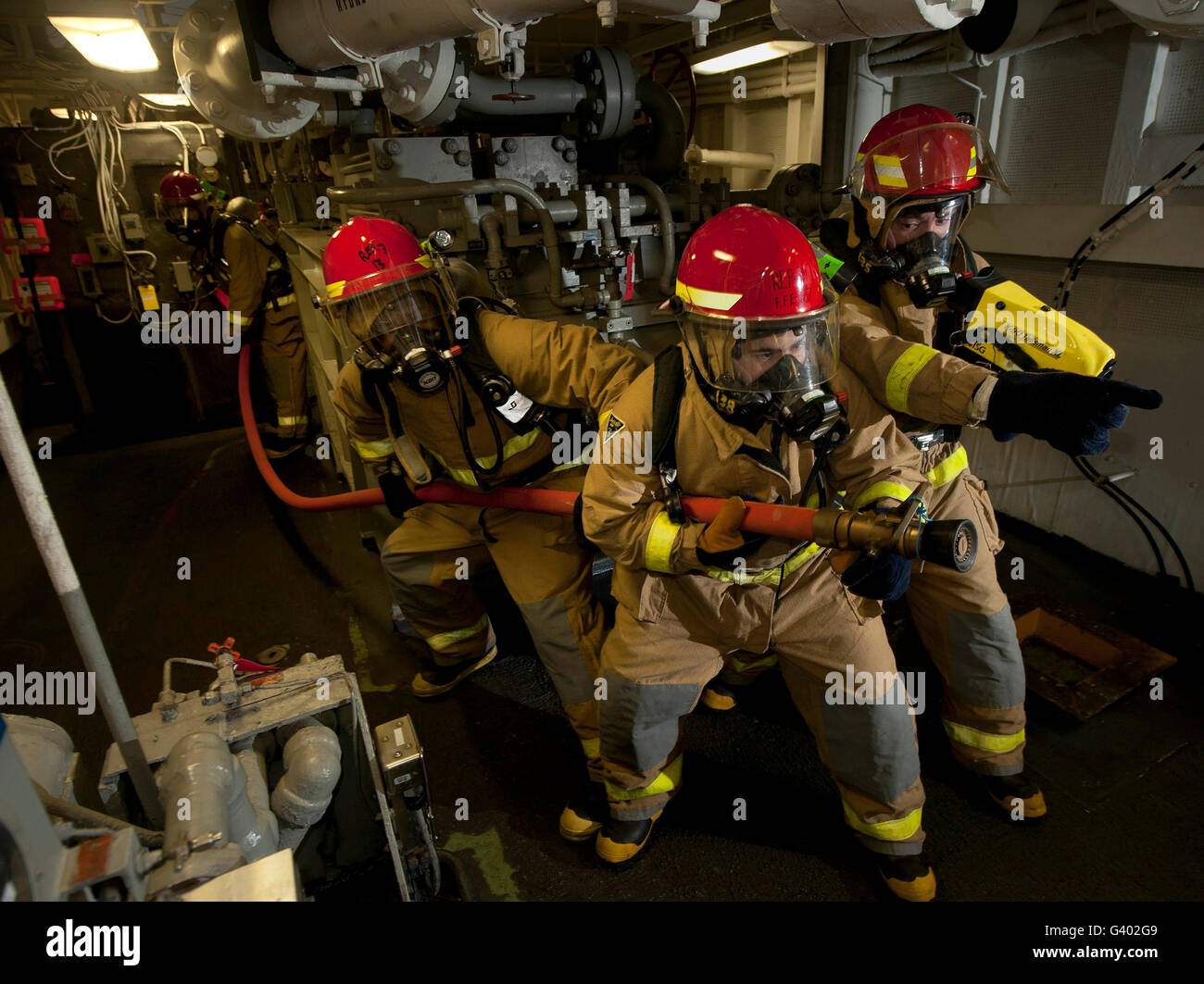Firemen combat a simulated fire aboard USS Carl Vinson. Stock Photo