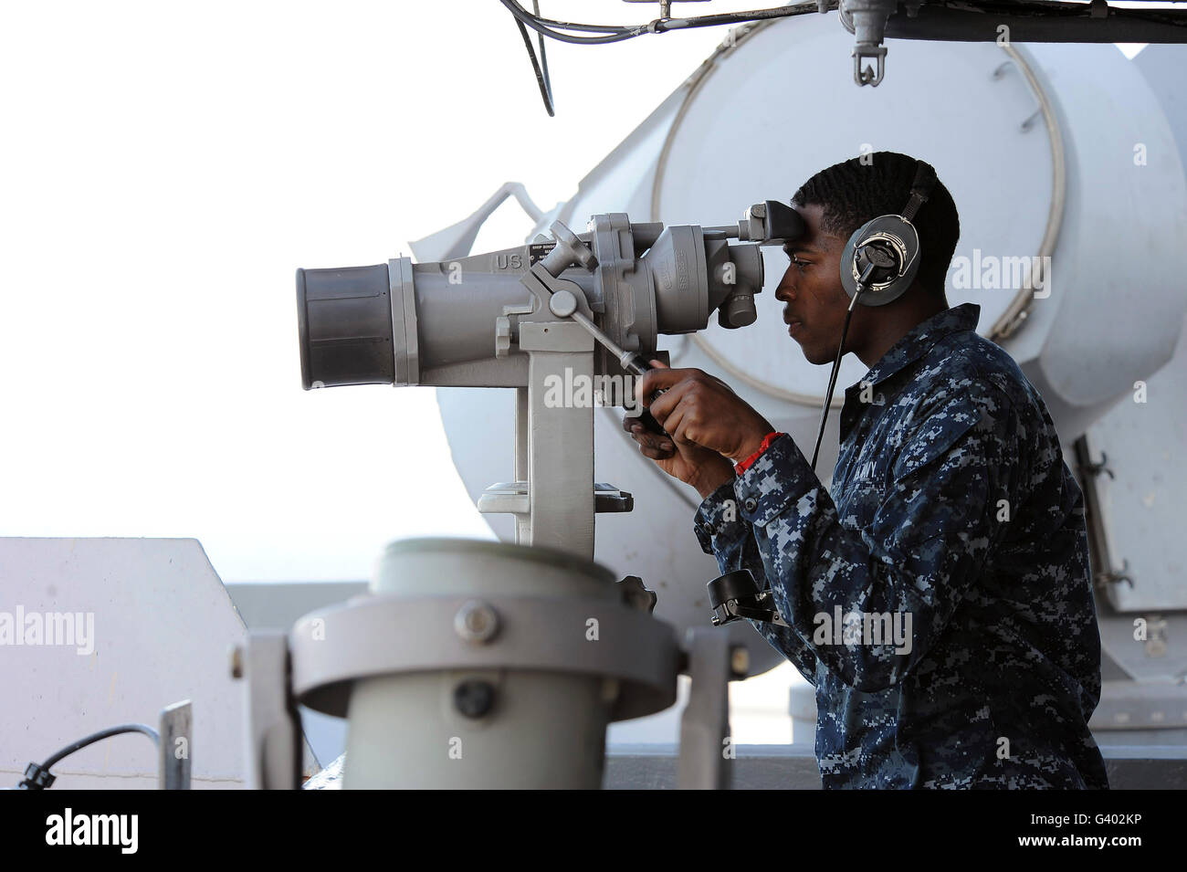 Seaman scans the horizon aboard USS Dwight D. Eisenhower. Stock Photo