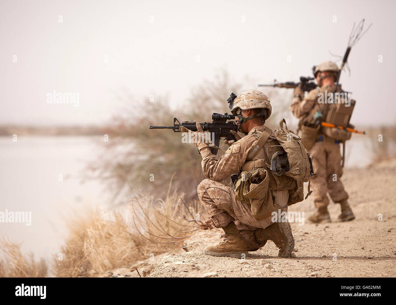 U.S. Marines sight in their weapons while on patrol in Afghanistan. Stock Photo