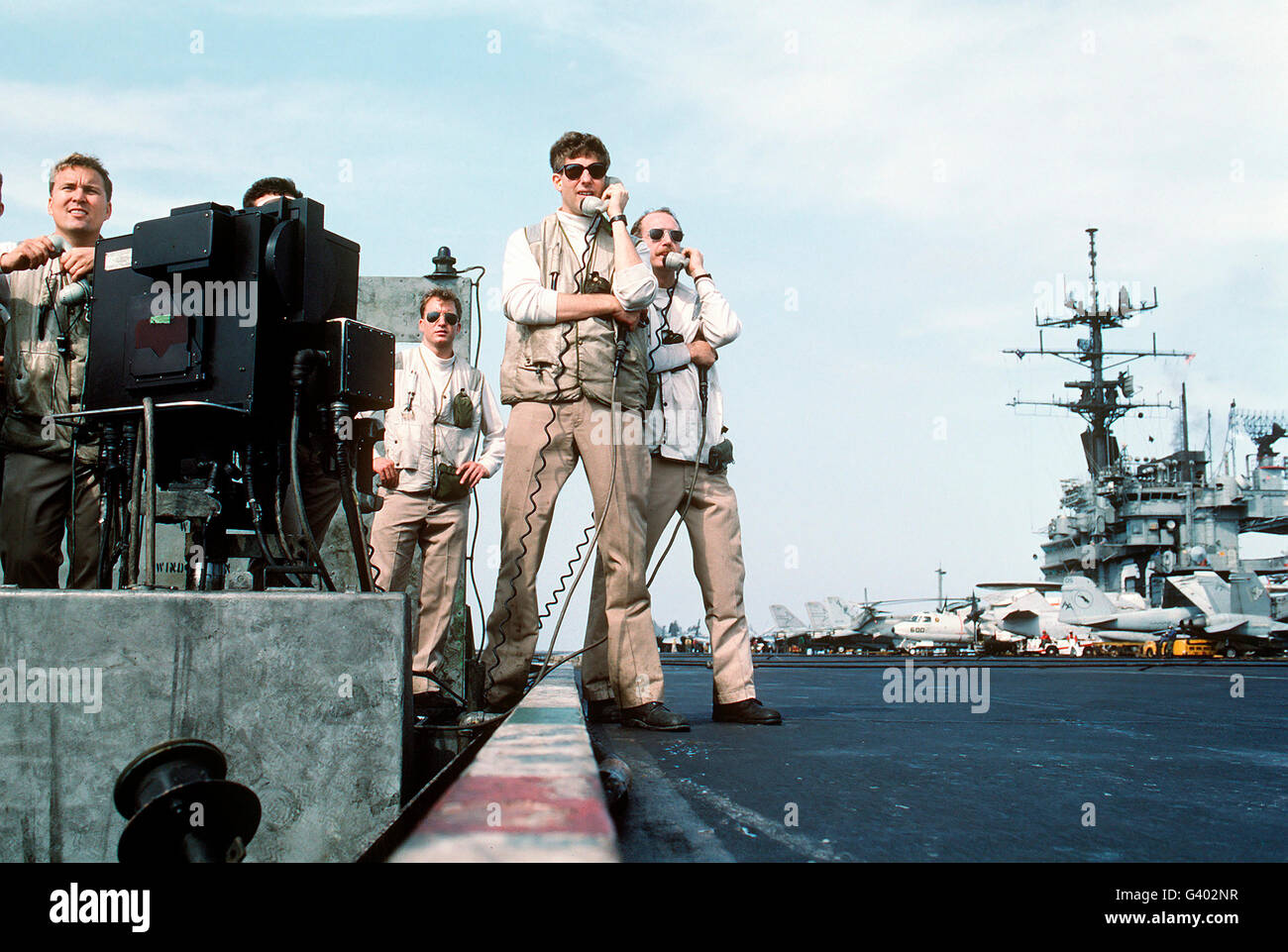 Landing signal officers guide an F-14 Tomcat aboard USS Saratoga. Stock Photo