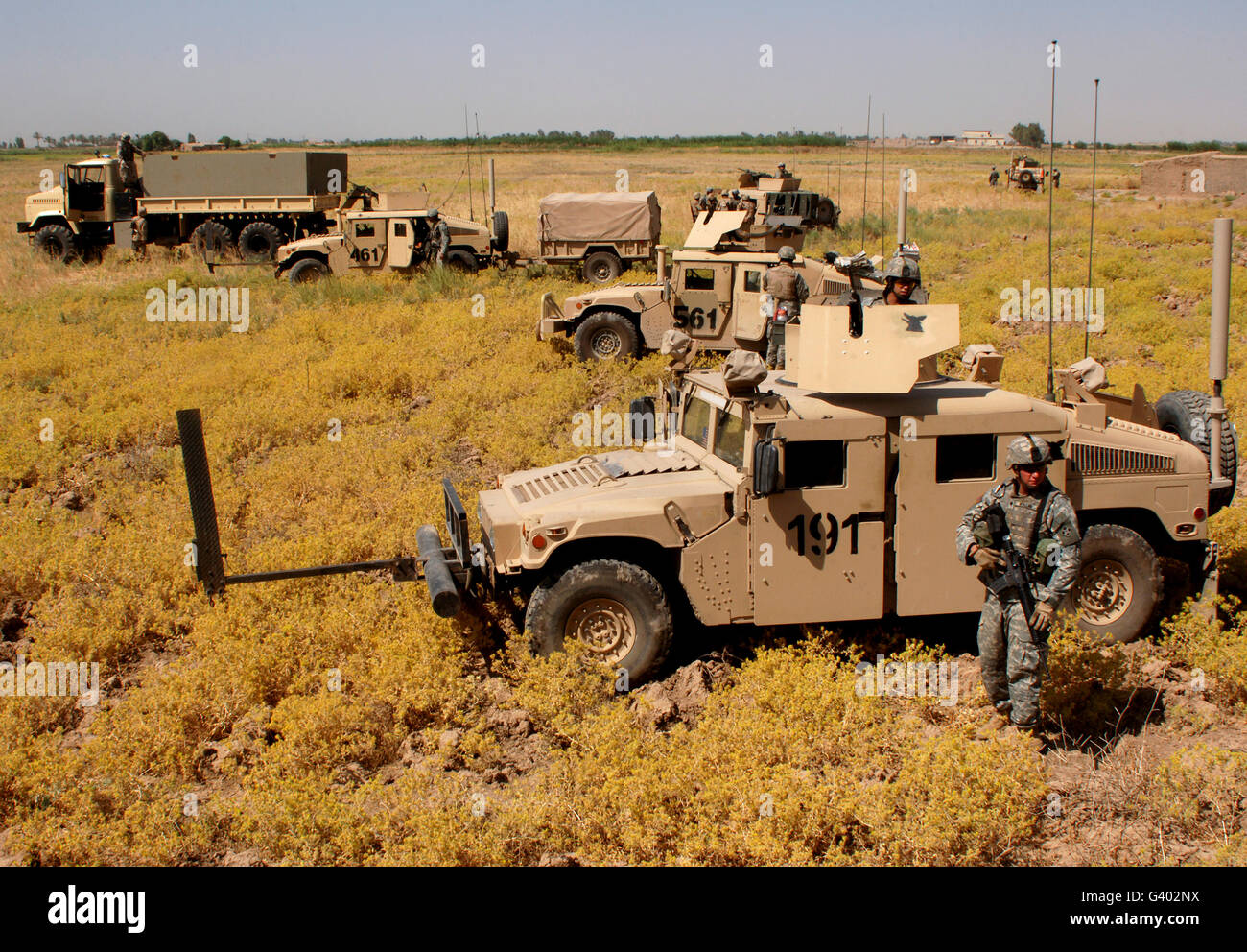 U.S. Army soldiers provide security from their M1114 humvees. Stock Photo