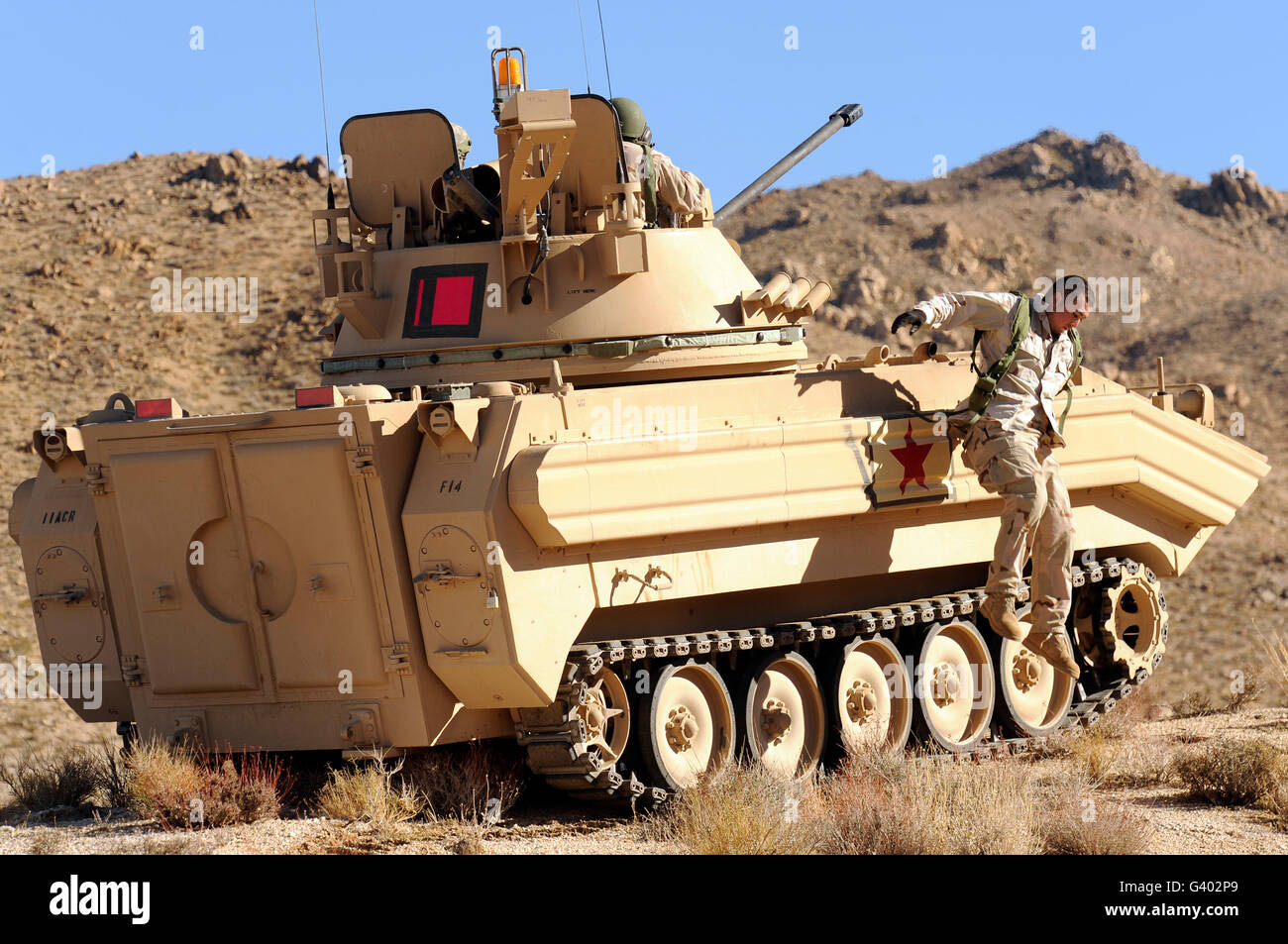 U.S. Army soldier jumps off an M113 armored personnel carrier. Stock Photo