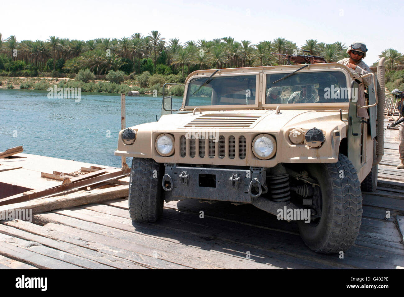 An M998 humvee crosses the Euphrates River on a pontoon bridge. Stock Photo