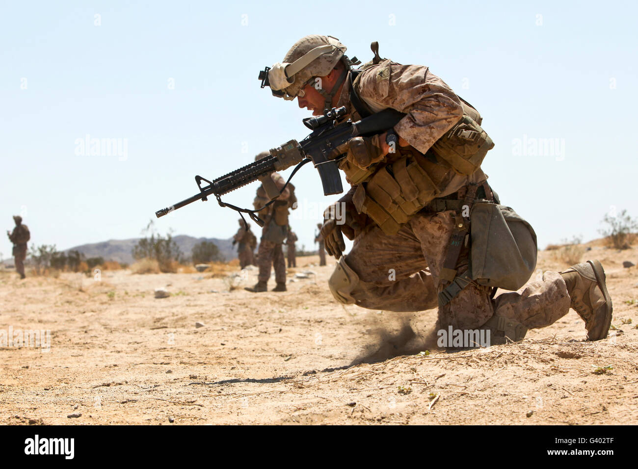 Rifleman kneels to the ground while conducting buddy rushes. Stock Photo