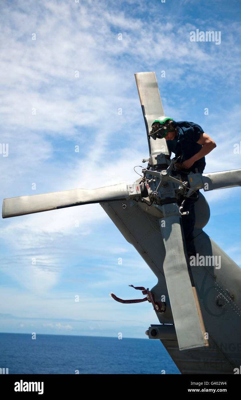 Aviation Machinist Mate conducts maintenance on the propeller of an MH-60S Sea Hawk. Stock Photo