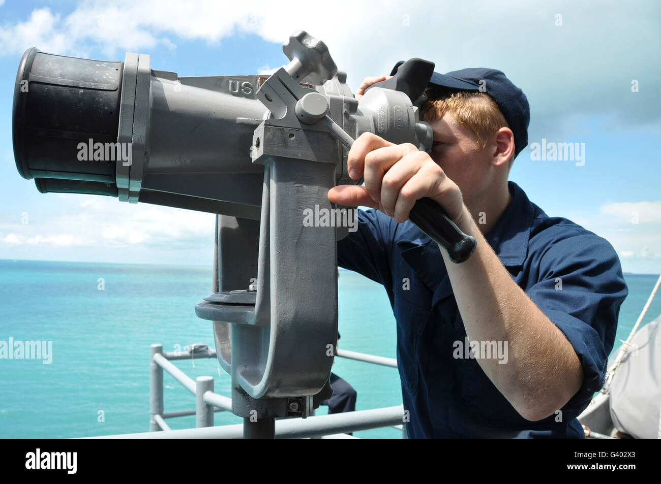 Seaman mans the big eyes aboard guided-missile cruiser USS Anzio. Stock Photo