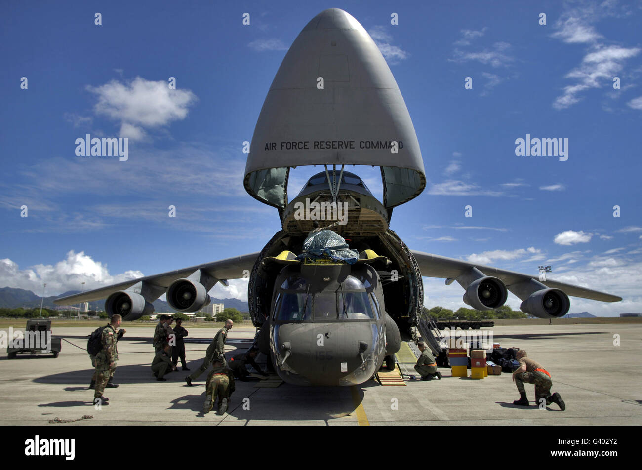 Airmen and soldiers load a CH-47 Chinook helicopter onto a C-5 Galaxy. Stock Photo