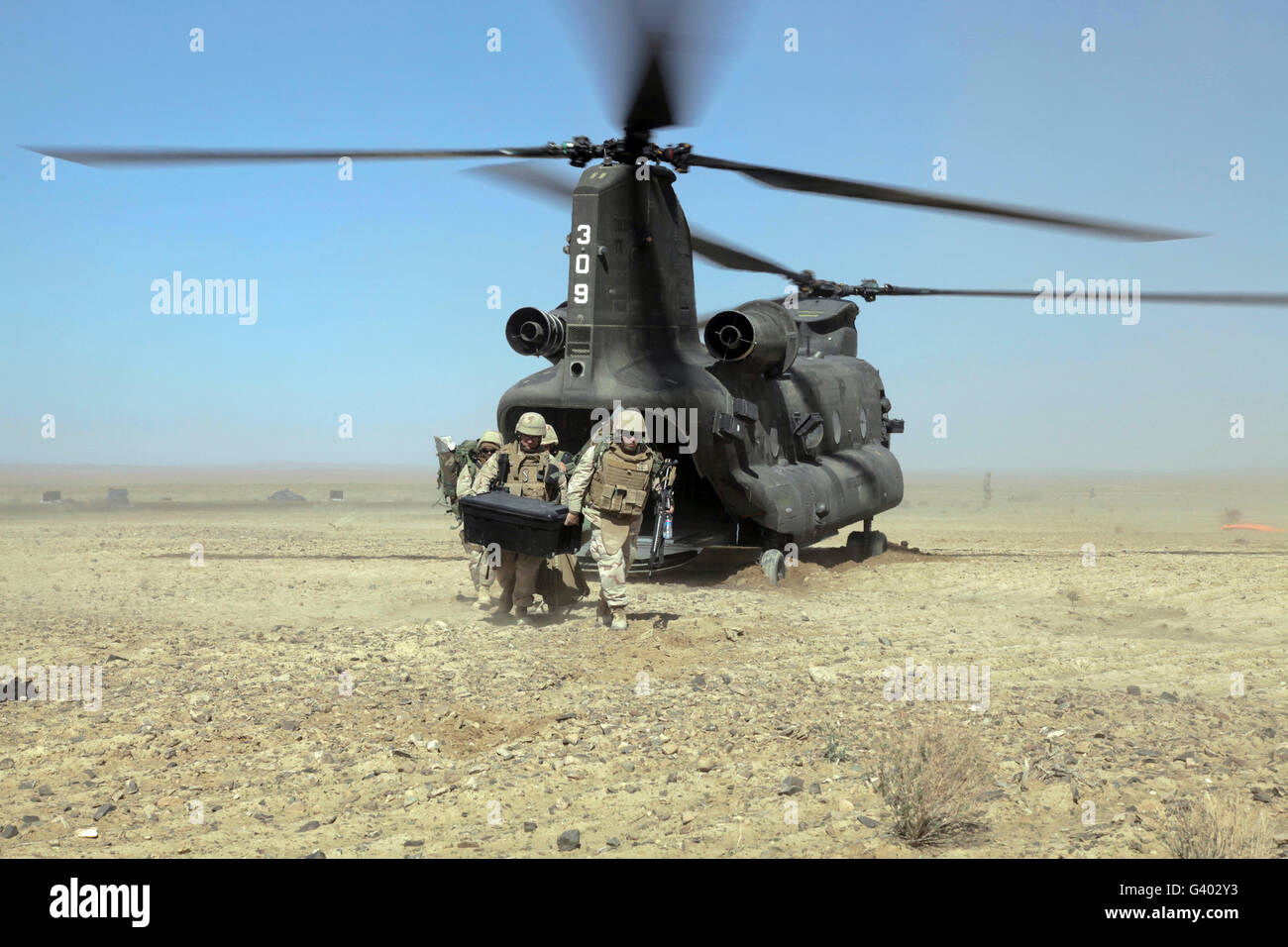 Seabees depart a CH-47 Chinook helicopter. Stock Photo