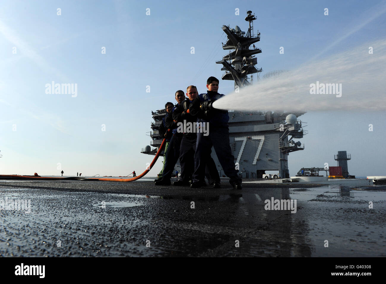 Sailors conduct hose team training on the flight deck of USS George H.W. Bush. Stock Photo