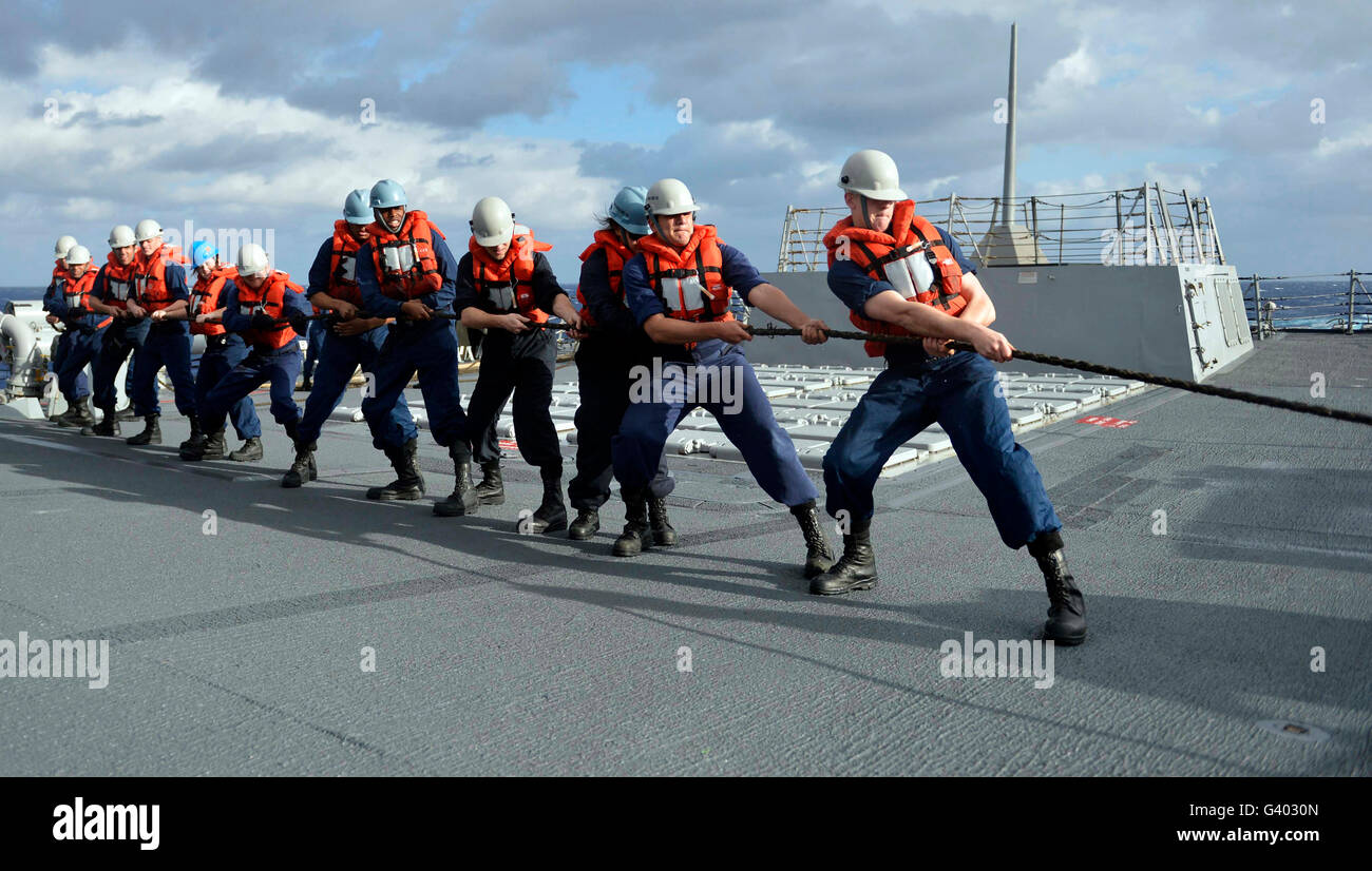 Line handlers heave around aboard USS William P. Lawrence. Stock Photo