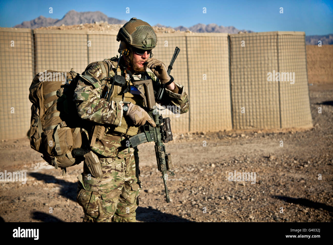 A coalition force member waits for a UH-60 Black Hawk helicopter. Stock Photo
