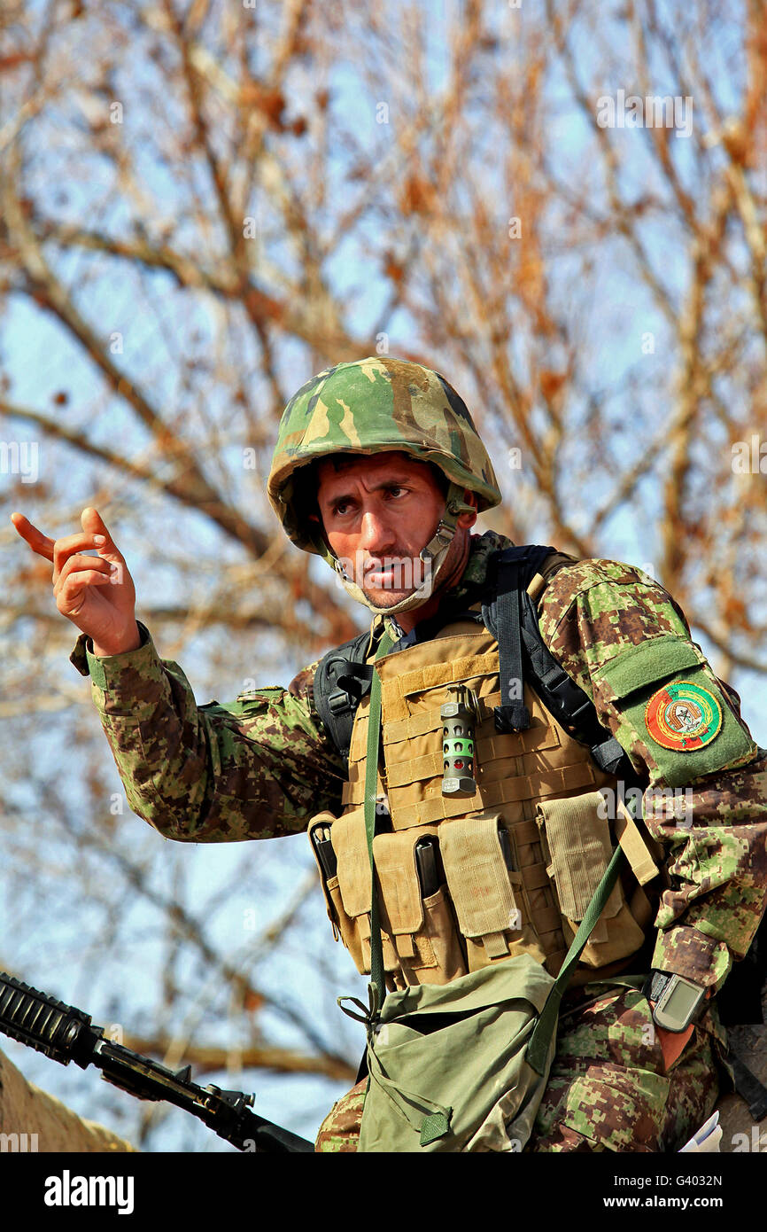 Afghan National Army soldier coordinates with his soldiers. Stock Photo