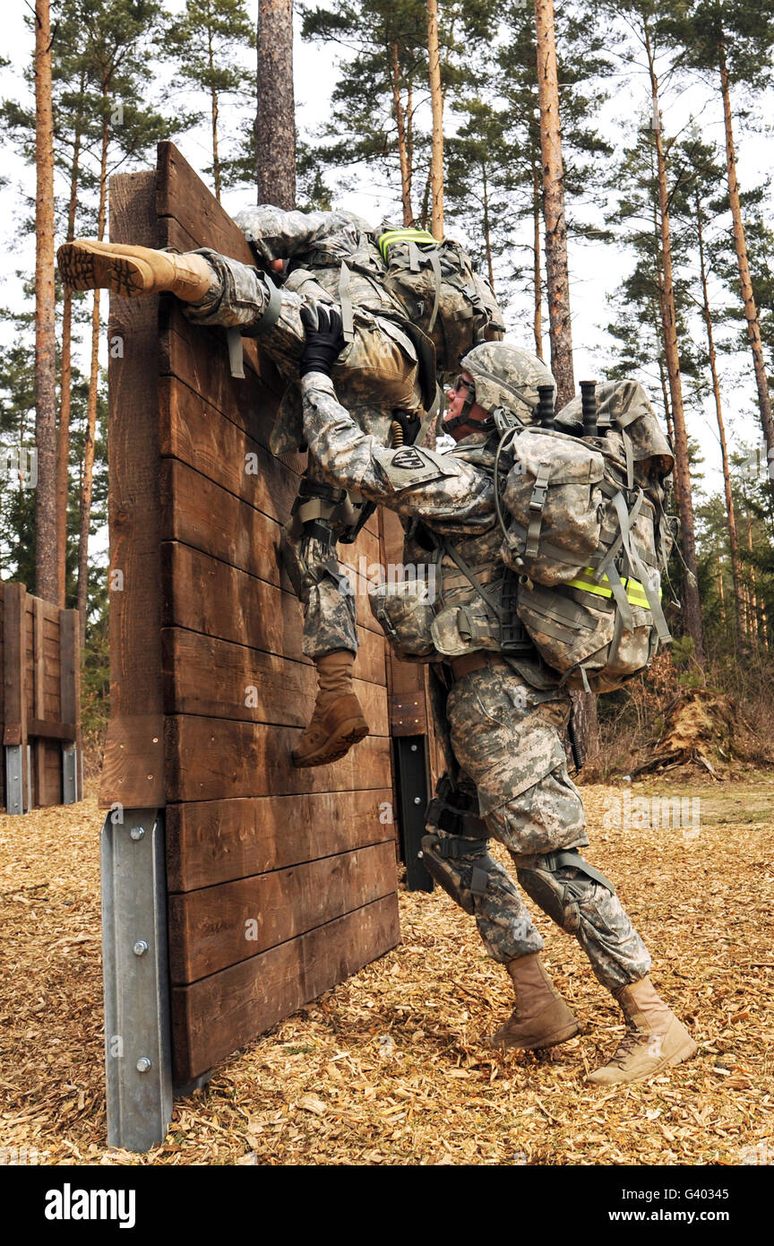 U.S. Army soldiers climb over an obstacle in Grafenwoehr, Germany. Stock Photo