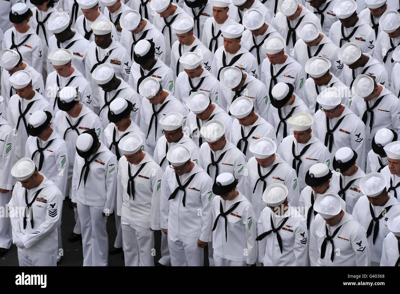 Sailors bow their heads during a change of command ceremony. Stock Photo