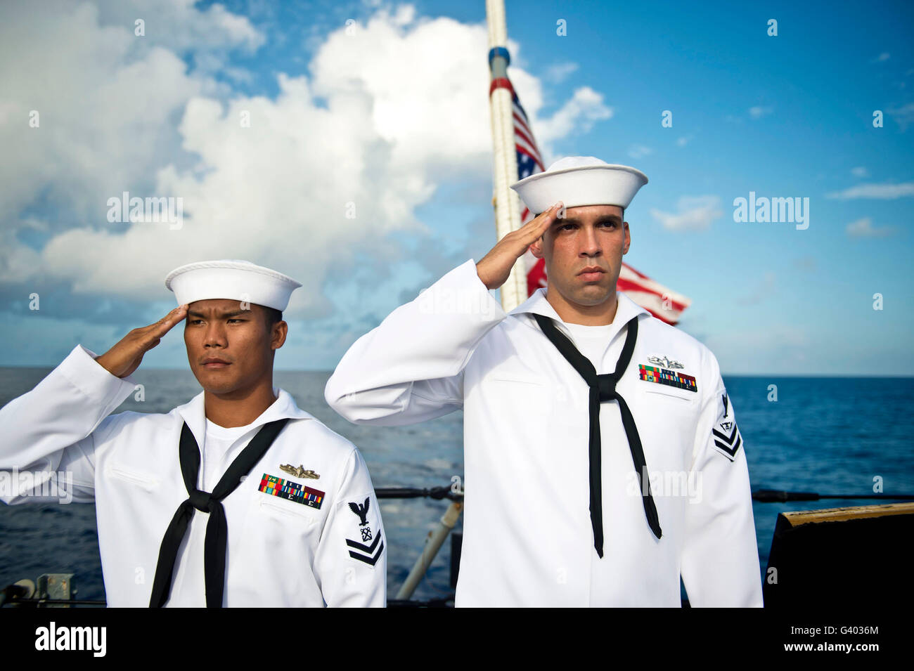 Sailors render a hand salute during a burial-at-sea ceremony. Stock Photo