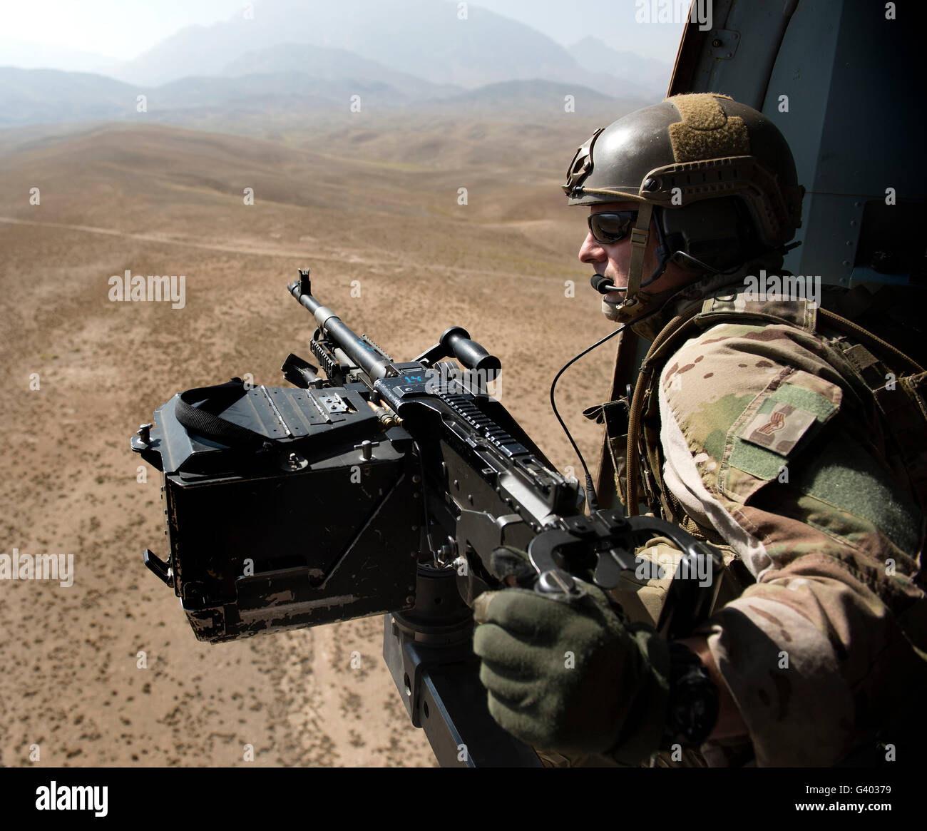 Door gunner scans the terrain over Afghanistan. Stock Photo