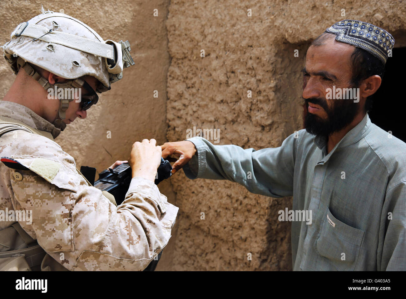U.S. Marine enrolls an Afghan into the Secure Electronic Enrollment Kit. Stock Photo