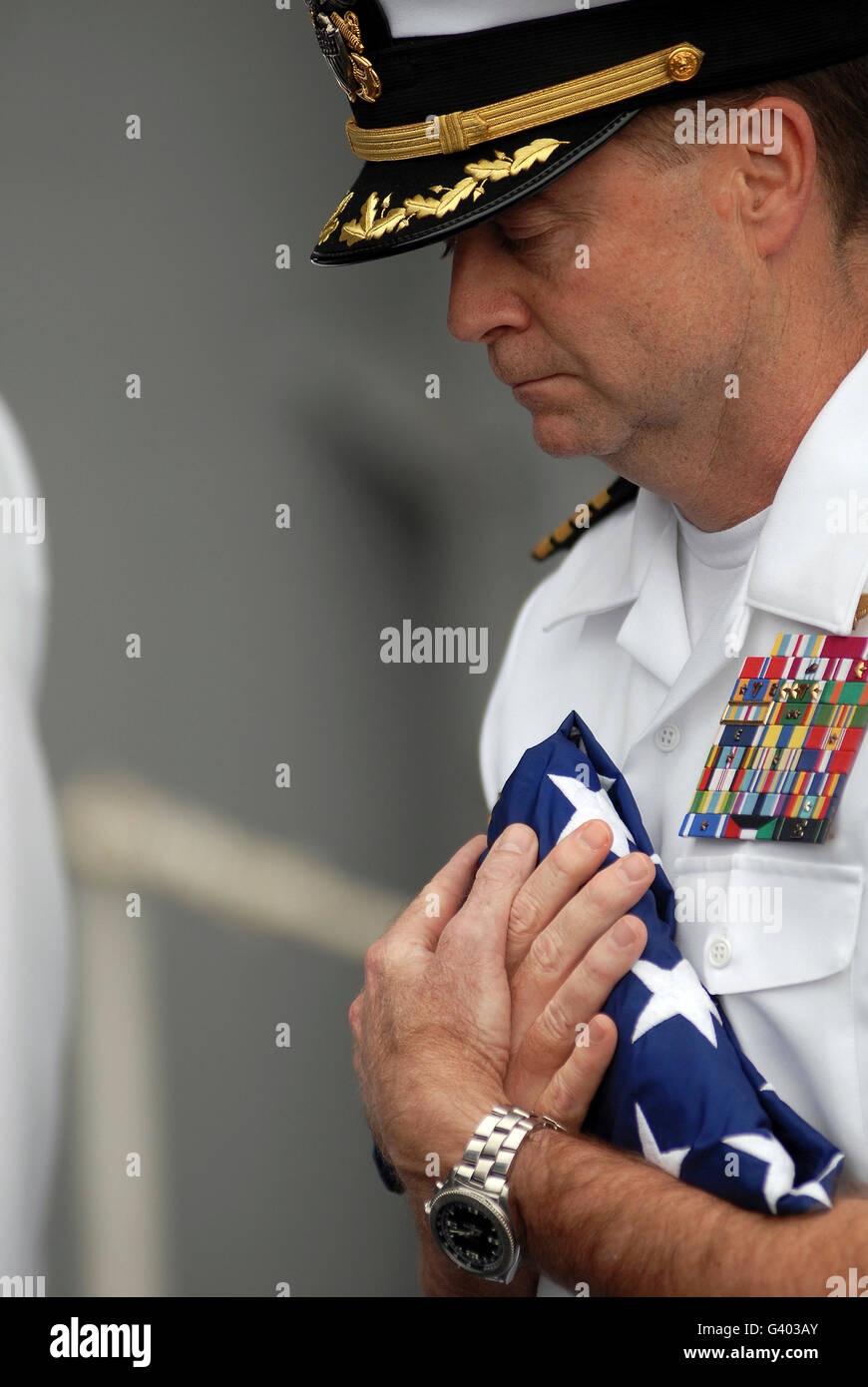 Commanding officer carries the American flag during a burial at sea. Stock Photo