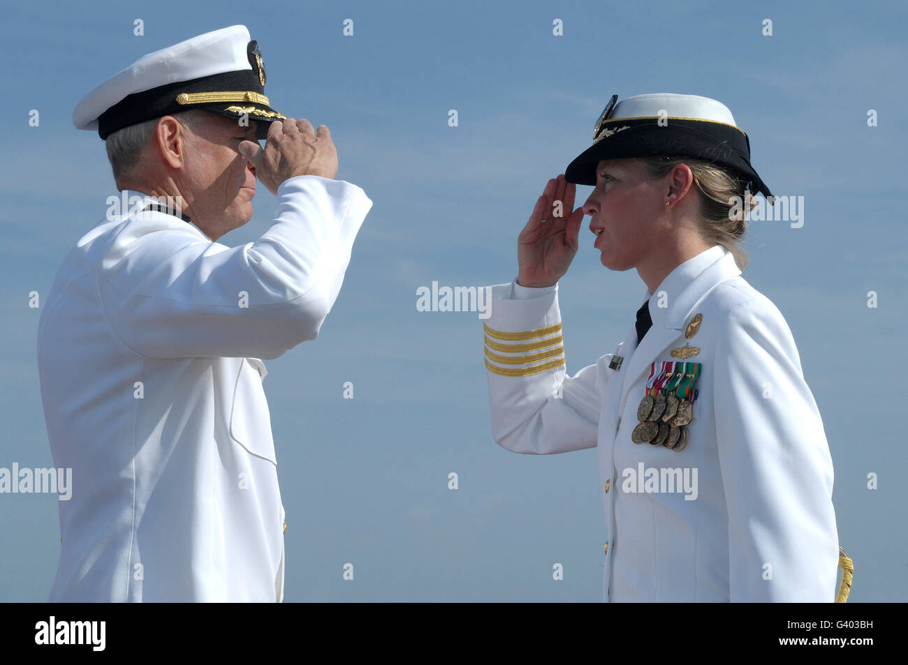 The first female commanding officer of Naval Station Norfolk salutes her fellow Captain. Stock Photo