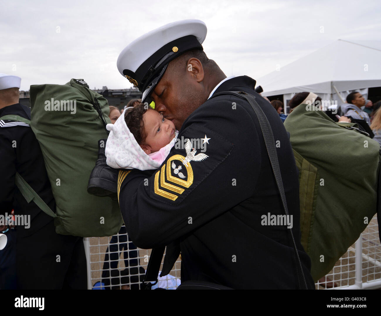 Aviation Ordnanceman kisses his newborn daughter during homecoming. Stock Photo