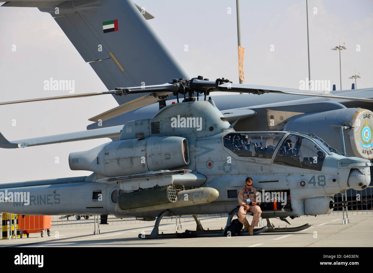 U.S. Marine takes a break sitting on an AH-1Z Cobra attack helicopter. Stock Photo