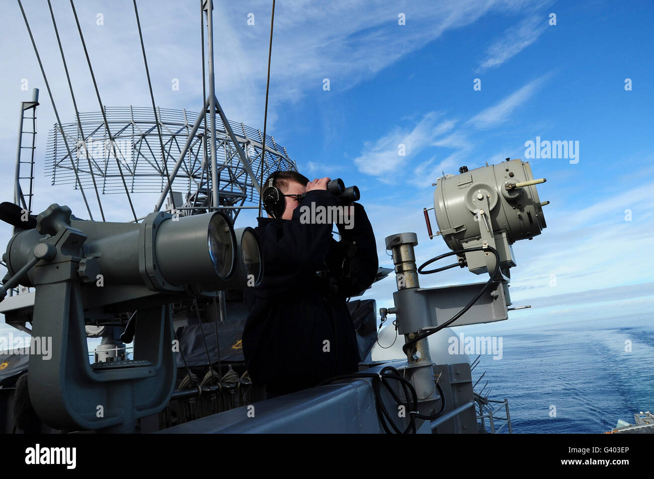 Seaman stands a port lookout watch aboard aircraft carrier USS Theodore Roosevelt. Stock Photo
