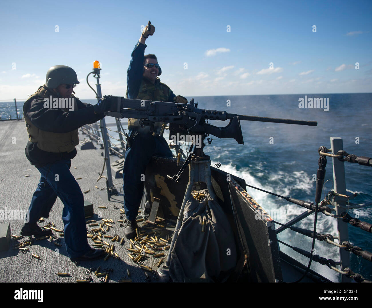 Sailors fire a .50-caliber machine gun aboard USS Roosevelt. Stock Photo