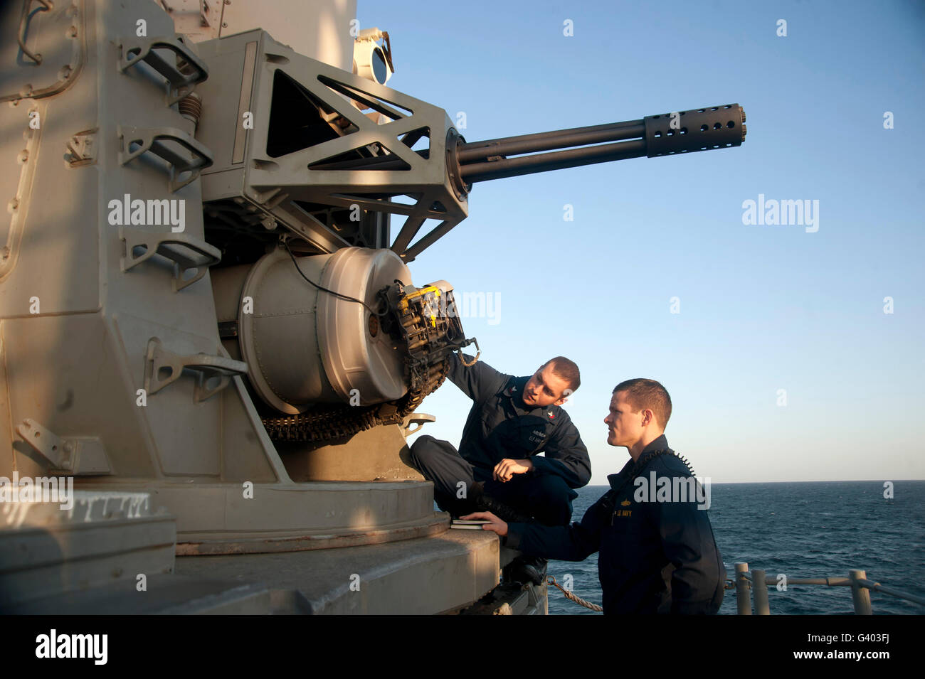 Operations Specialist and Ensign inspect a close-in weapons system. Stock Photo