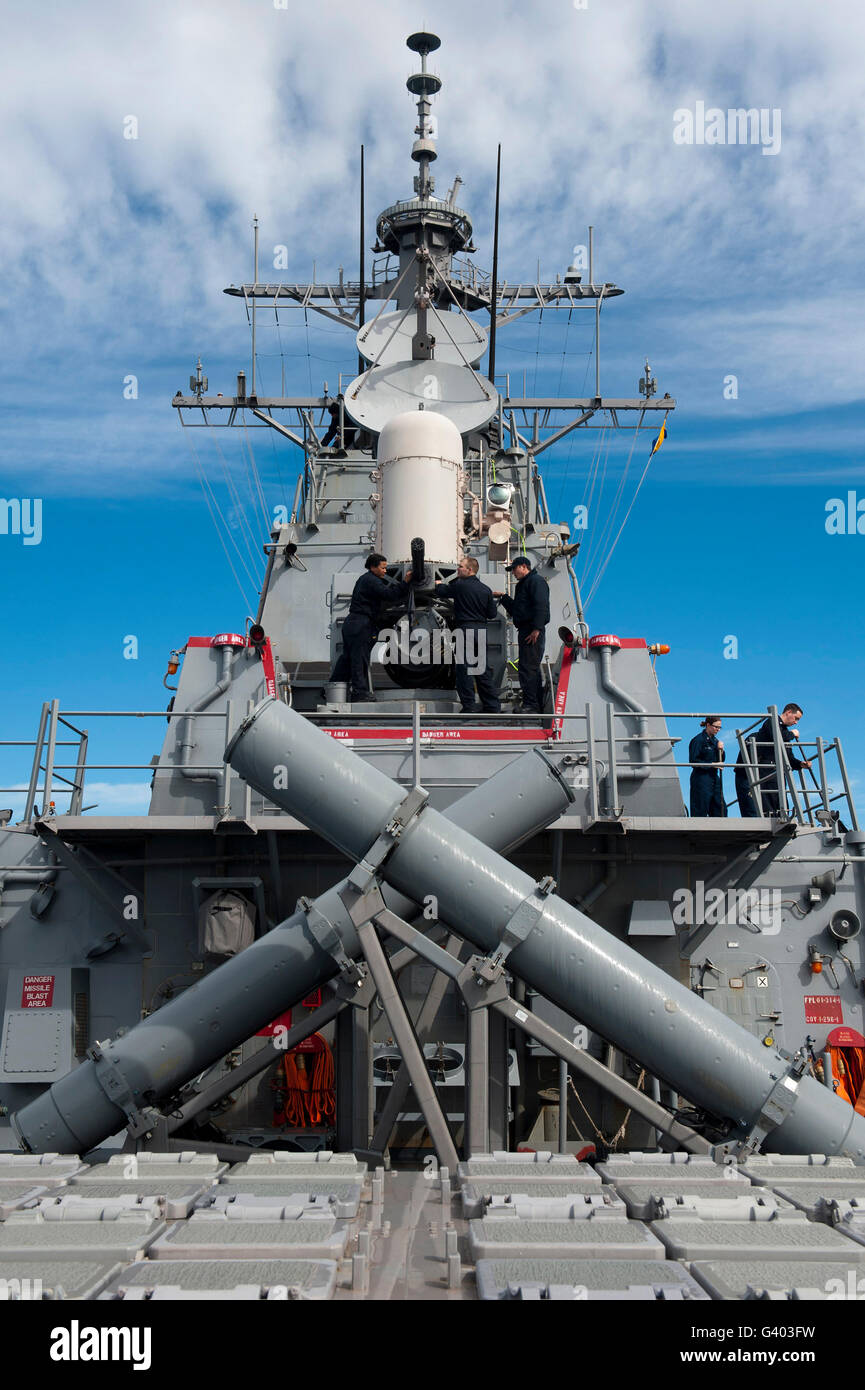 Sailors wipe away sea salt from a close-in weapons system. Stock Photo