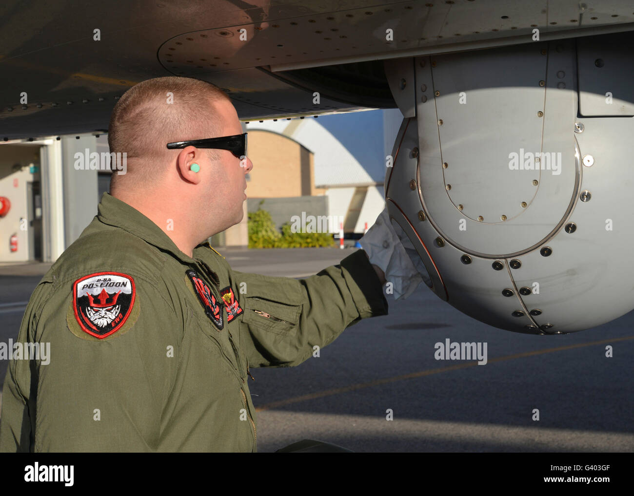 An electronic warfare operator wipes down the camera lens on a P-8A Poseidon. Stock Photo