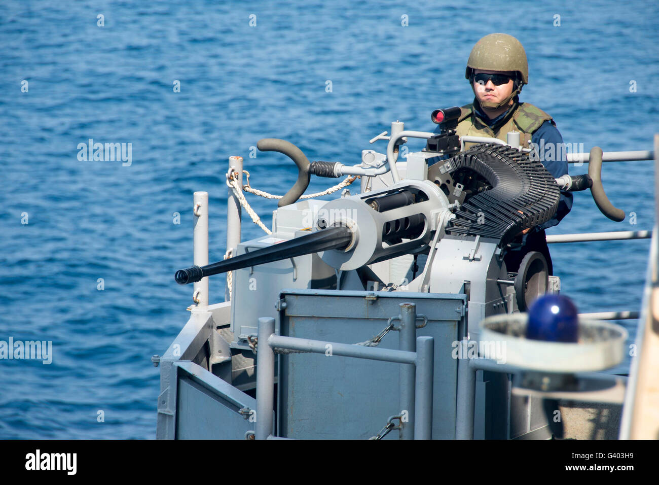 Gunner's Mate mans the Mark 38  machine gun aboard USS Iwo Jima. Stock Photo