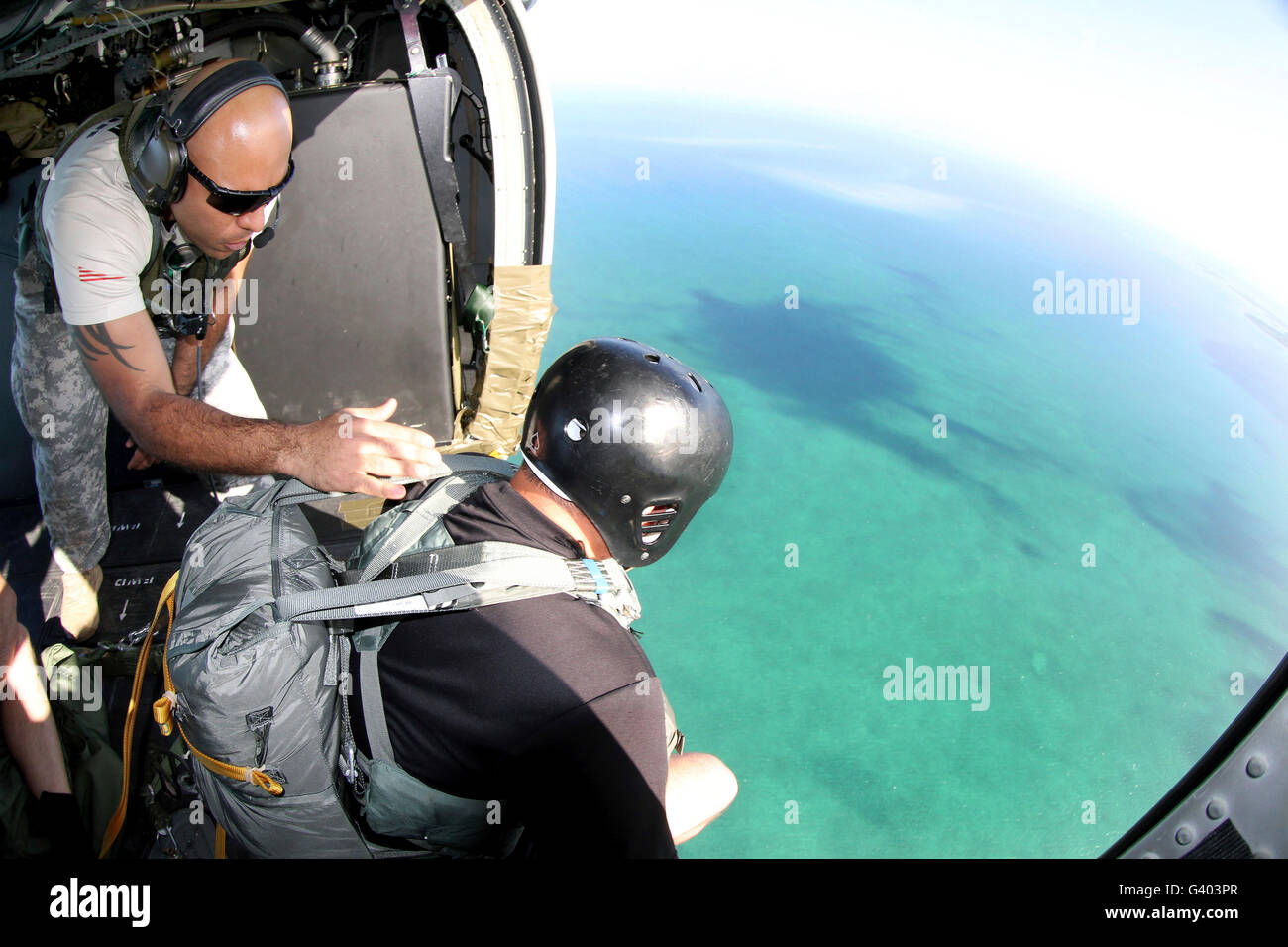 U.S. Army jumpmaster prepares a paratrooper to jump out of a MH60