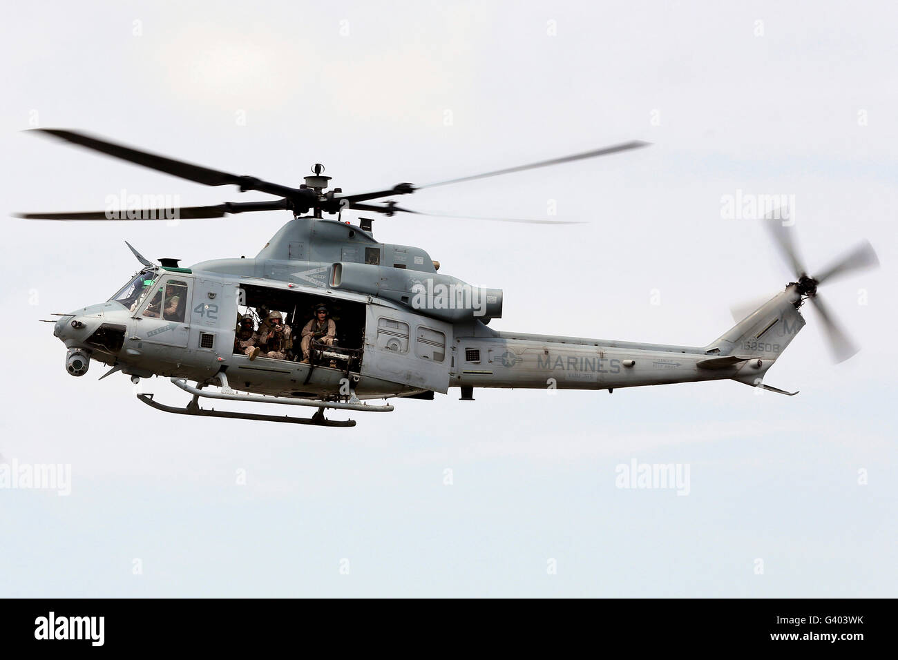 A UH-1Y Huey hovers around a ship. Stock Photo