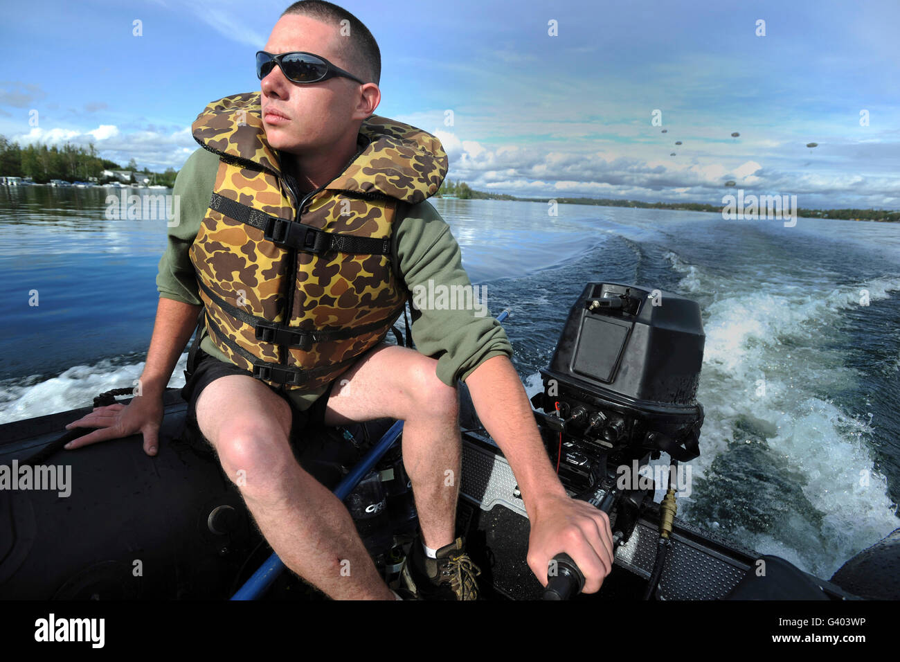 U.S. Army Soldier pilots a Zodiac boat in Big Lake, Alaska. Stock Photo