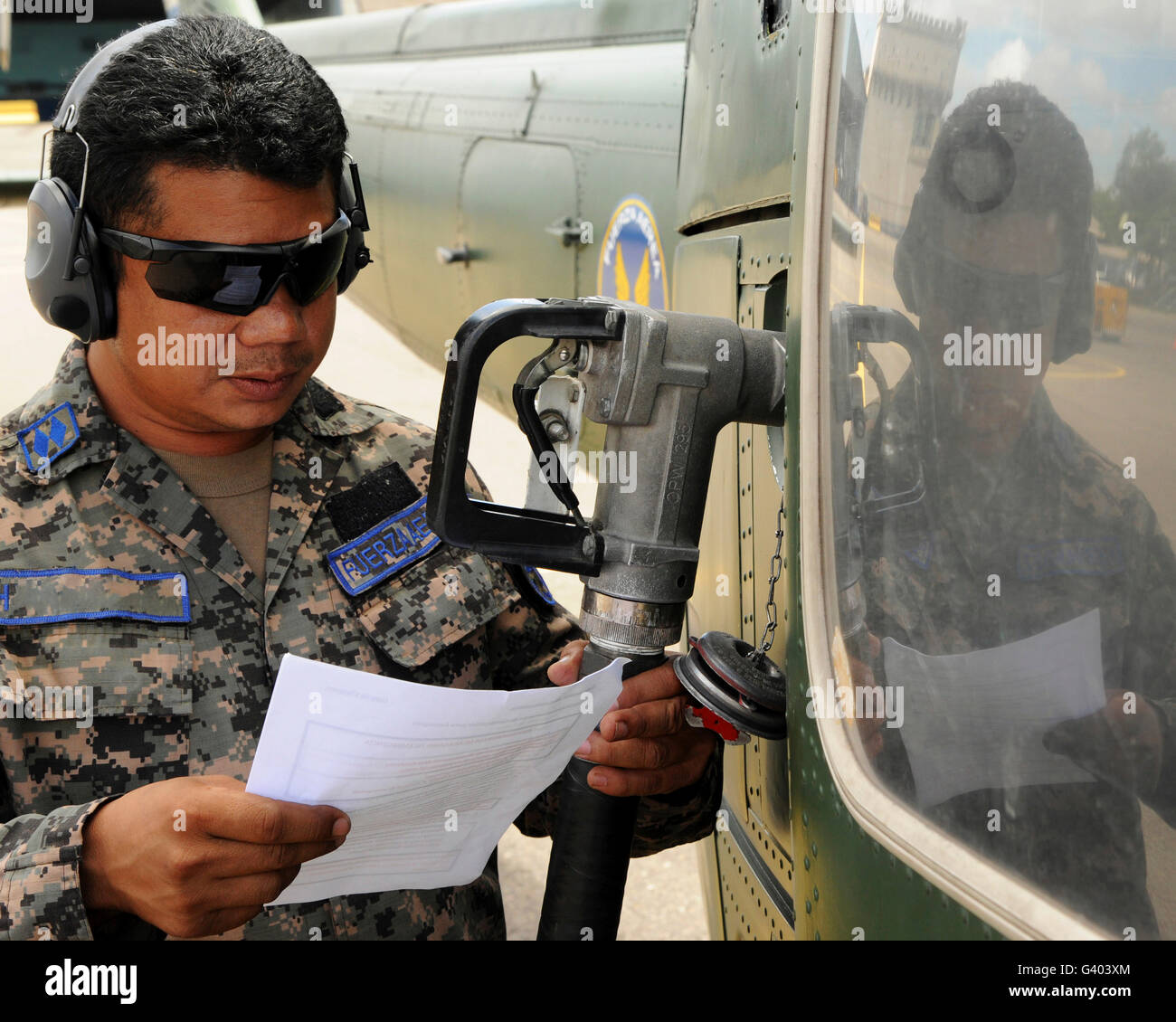 A Honduran crew chief consults his aircraft fueling checklist. Stock Photo