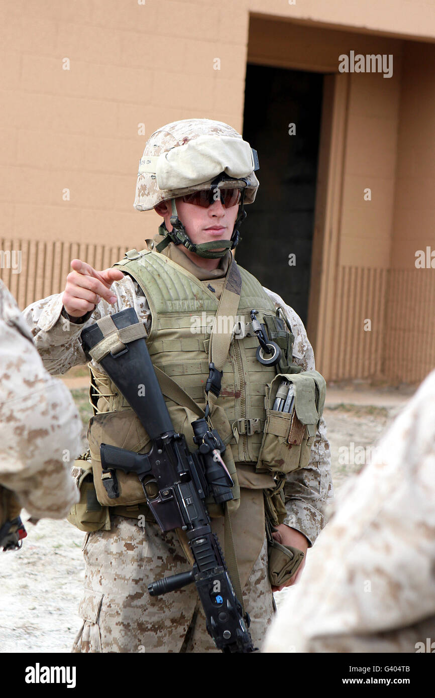 A marine instructs troops on the proper handling techniques when using a M16. Stock Photo