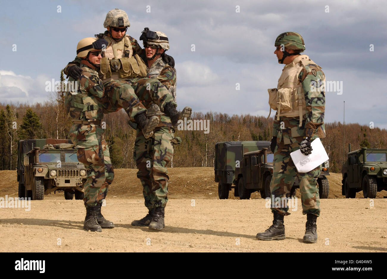 Soldiers demonstrate the four-handed seat-carry during self-aid buddy care training. Stock Photo