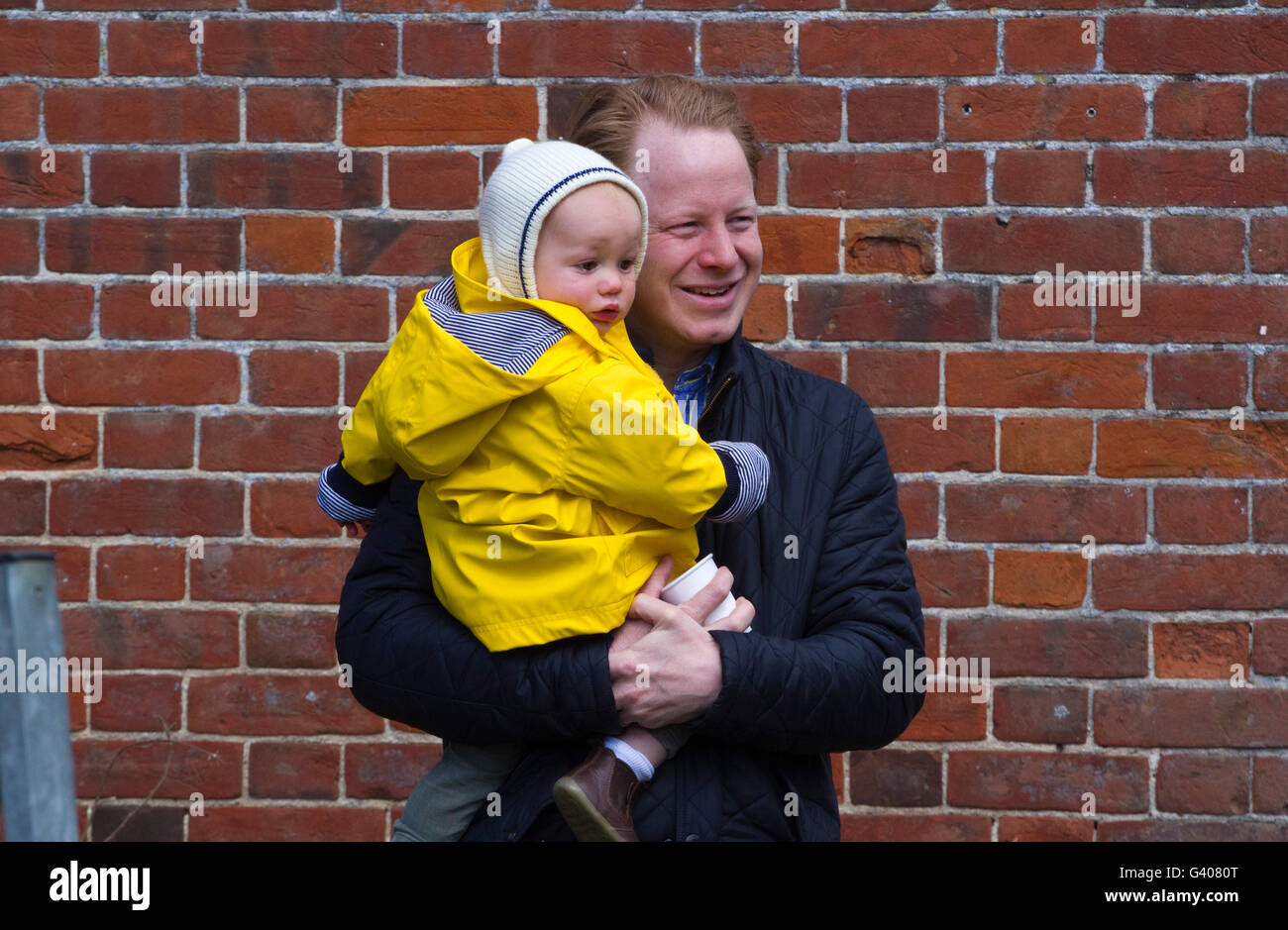 The Honourable Ben Gummer MP smiling and holding an unhappy child that very probably is his son Stock Photo