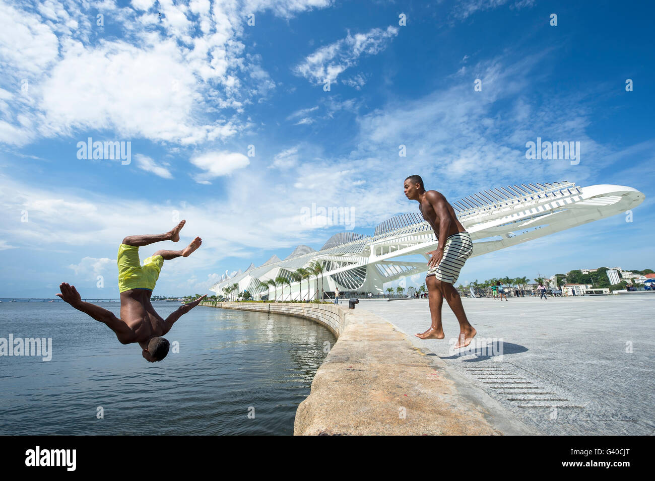RIO DE JANEIRO - FEBRUARY 25, 2016: Young Brazilians jump into Guanabara Bay from the wall at Maua Plaza, Porto Maravilha. Stock Photo