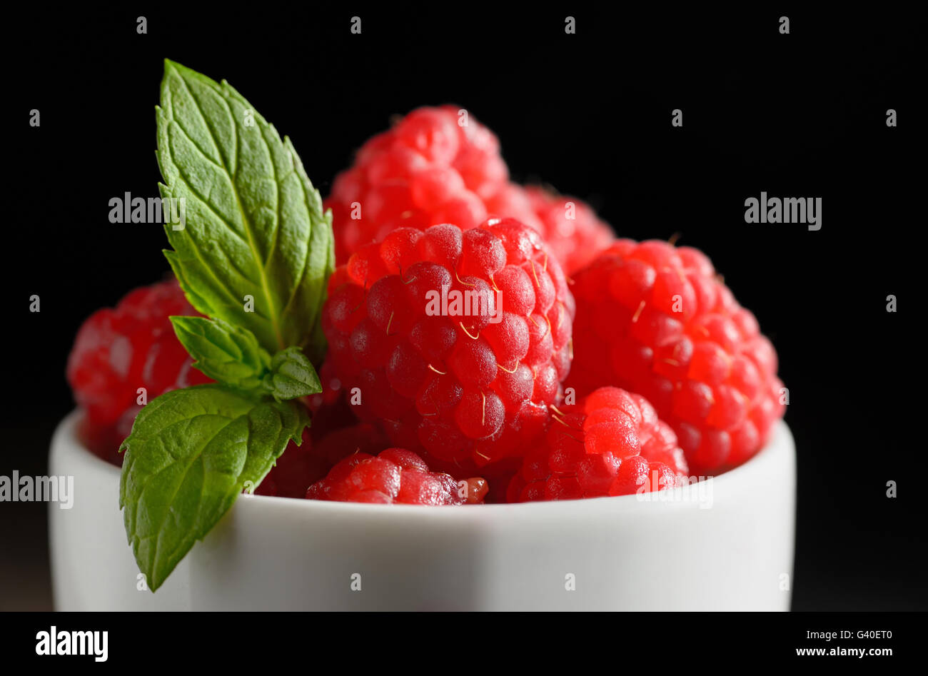 Wild raspberry  in ceramic bowl and mint leaves Stock Photo